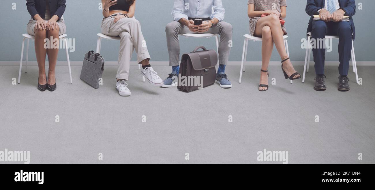 Business people sitting and waiting for a job interview or a meeting, blank copy space, recruitment and employment concept Stock Photo