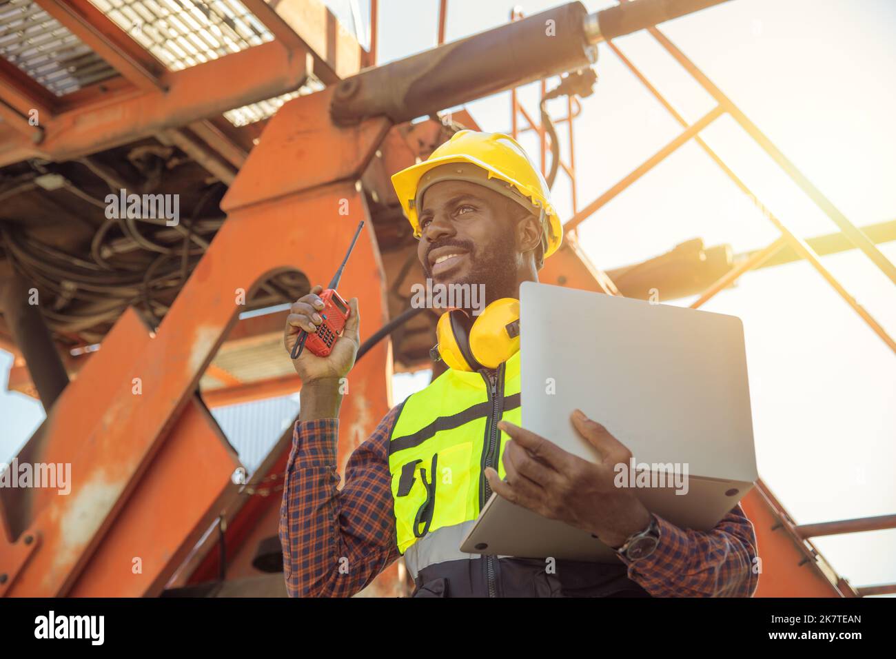 happy worker foreman working loading control in cargo shipping industry. engineer work in contruction site. Stock Photo