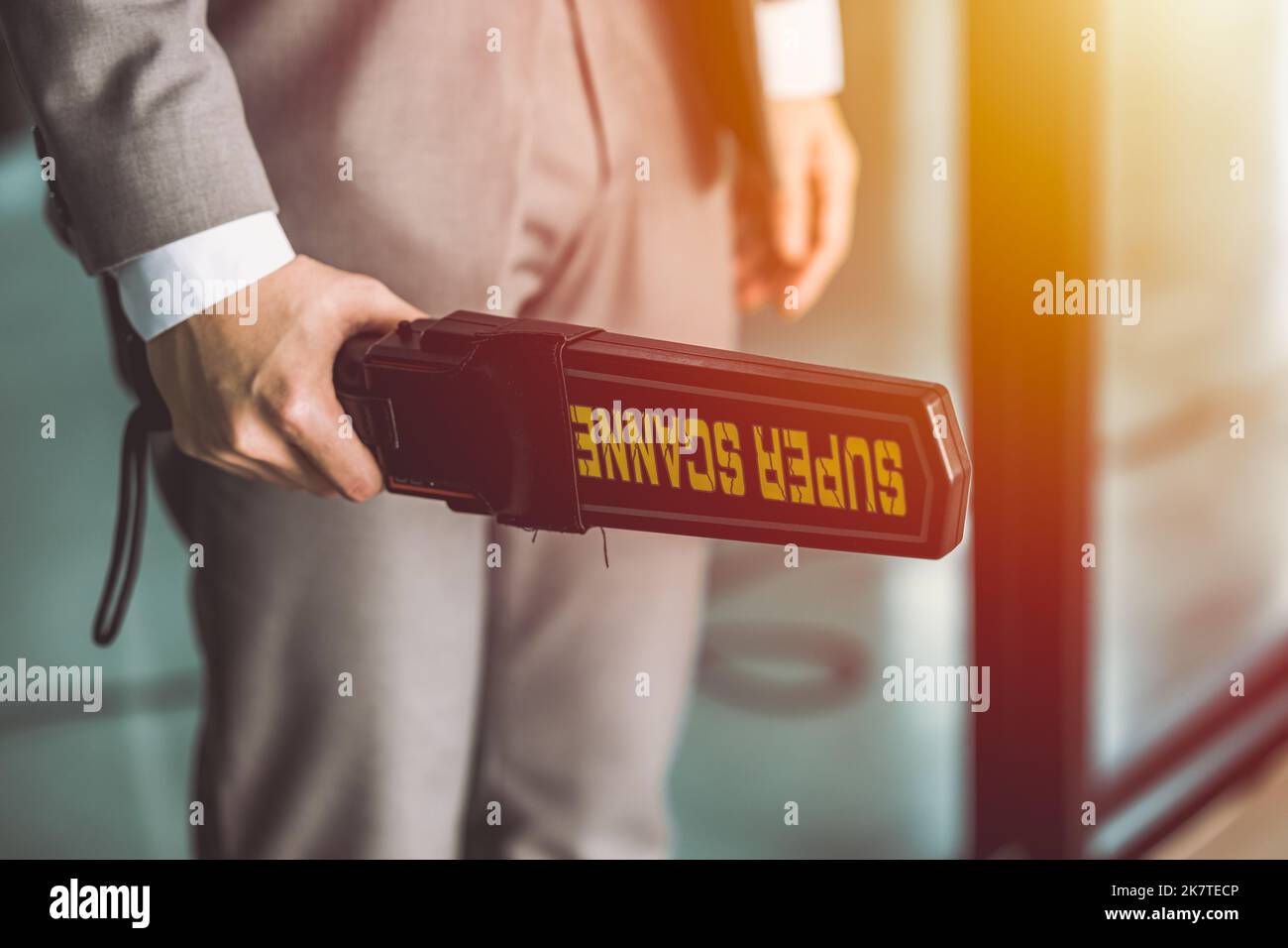 airport security guard officer with metal scanner or weapon detector at