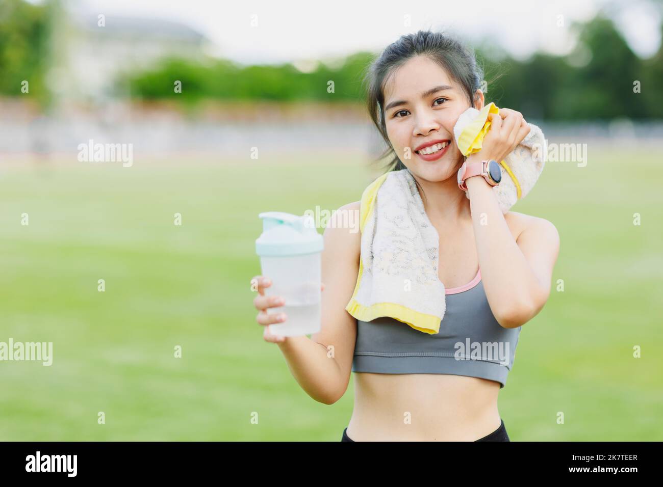 sport teen girl relax smile drinking water wipe sweat finish exercise outdoor Stock Photo
