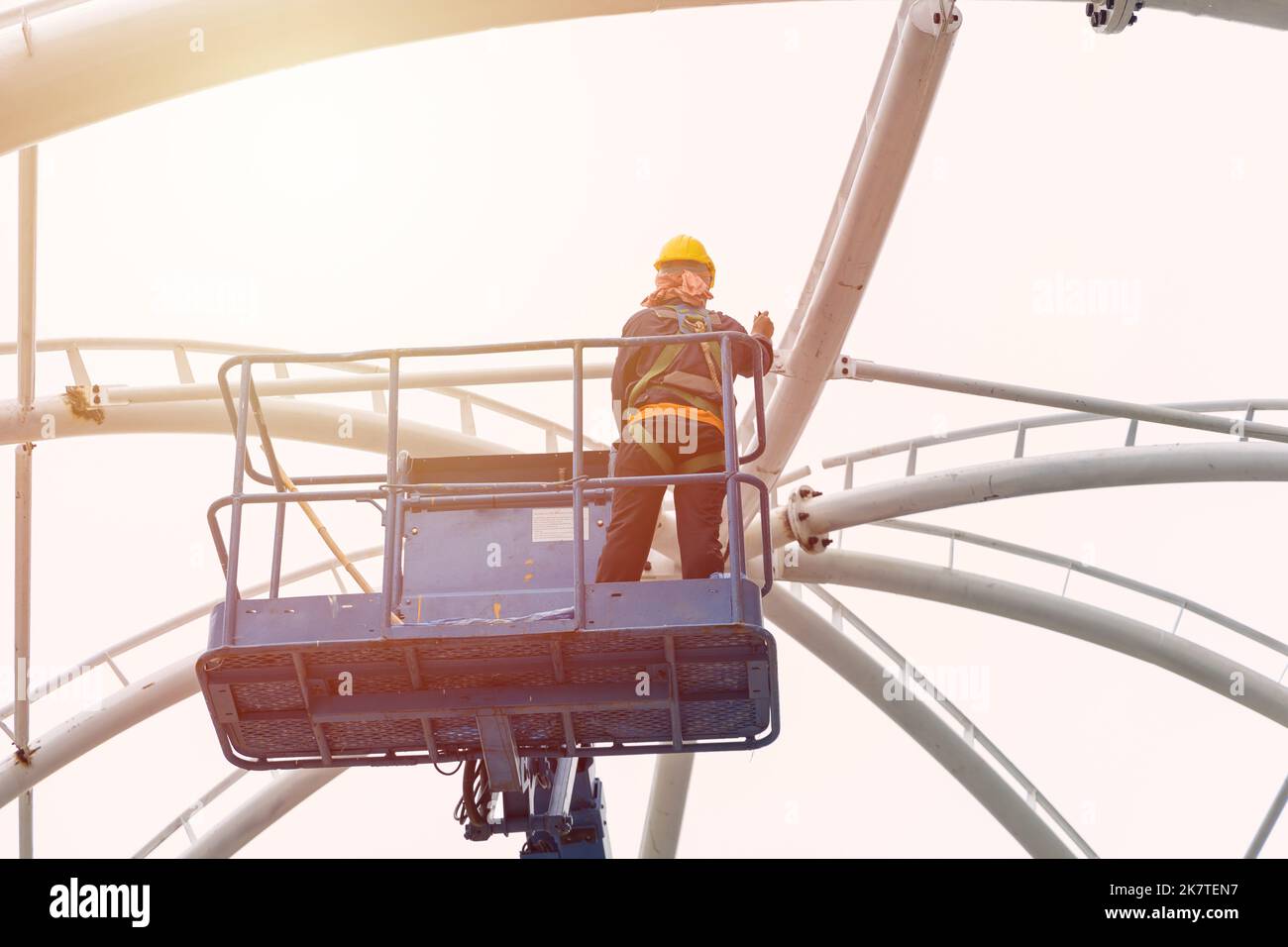 construction worker work at high construction roof on crane platform lift with safety equipment Stock Photo