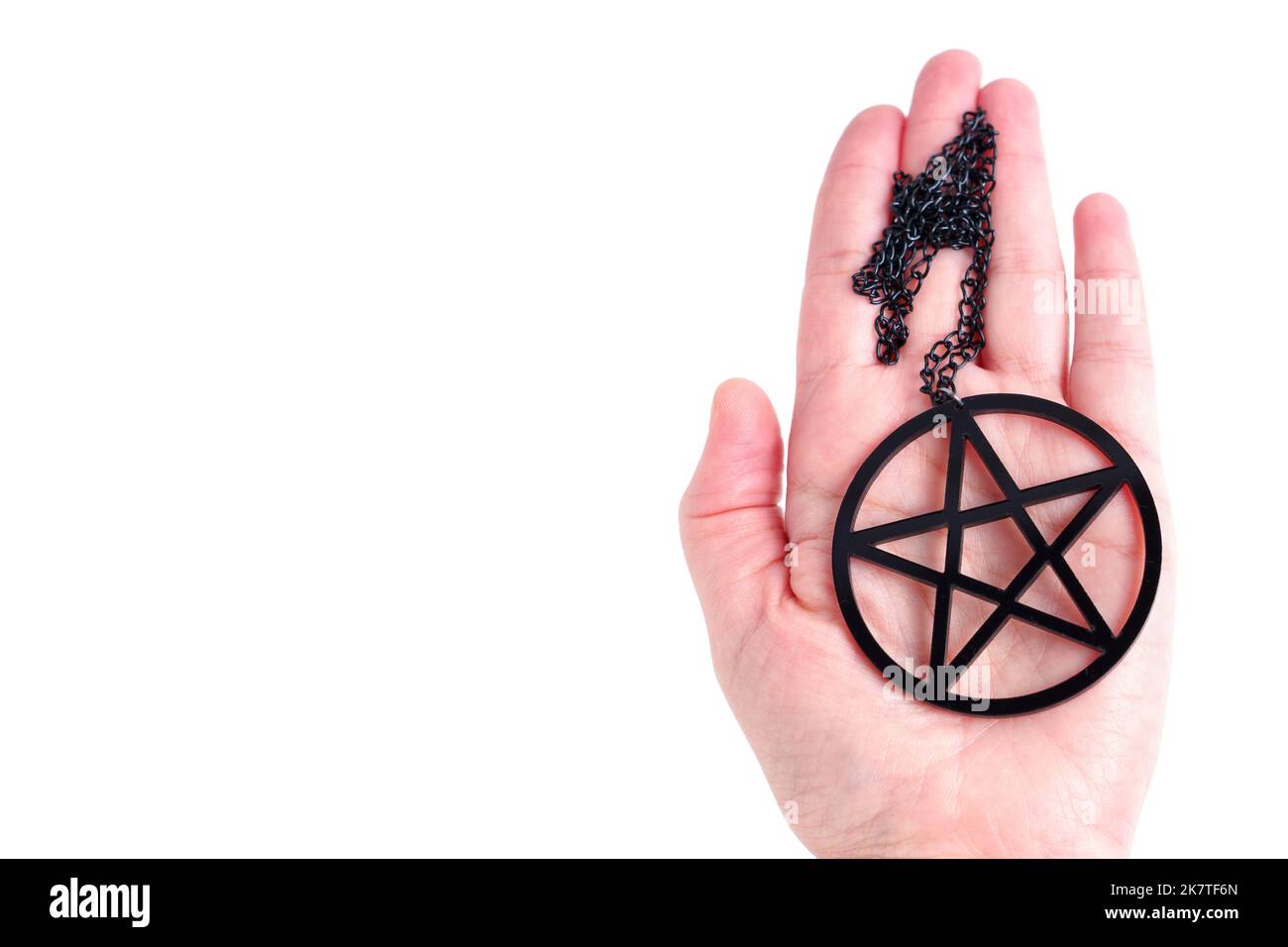 Large black pentagram pendant in hand isolated on white background with copy space Stock Photo