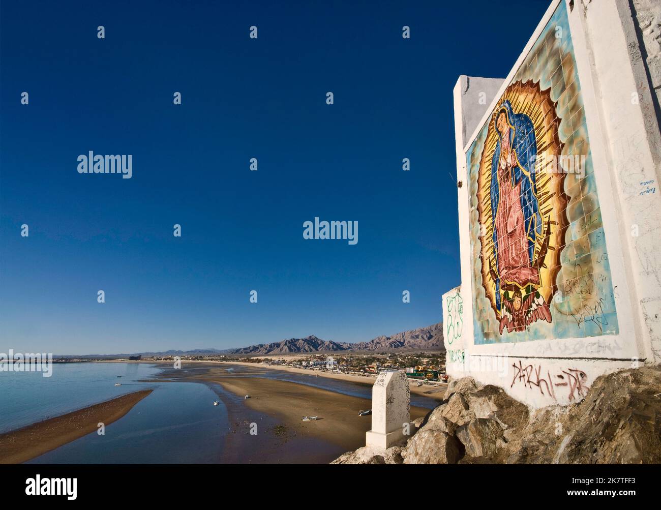 Tile mosaic of Virgin of Guadalupe at shrine on top of Cerro el Machorro, San Felipe in distance, Baja California, Mexico Stock Photo