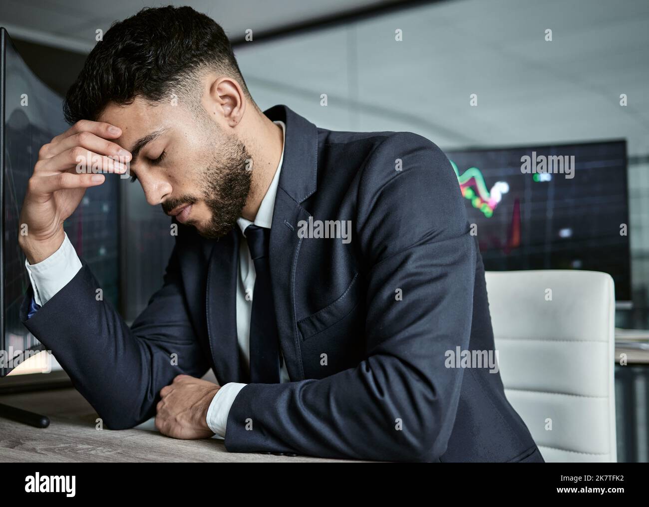 Businessman with depression on the stock market, trading during a financial crisis. Stressed trader in a bear market, looking at stocks crashing Stock Photo