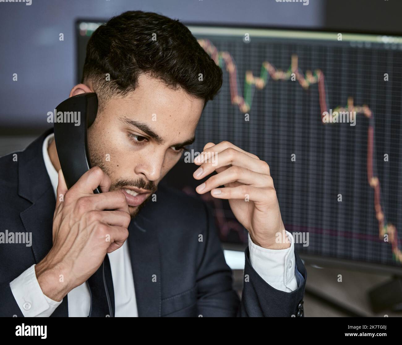 Stressed businessman on the phone, trading on the stock market during a financial crisis. Trader in a bear market with stocks crashing. Market crash Stock Photo