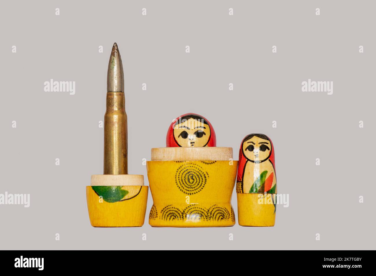 The bullet is embedded in the national Russian nesting doll on an isolated background, the country is a terrorist, war Stock Photo