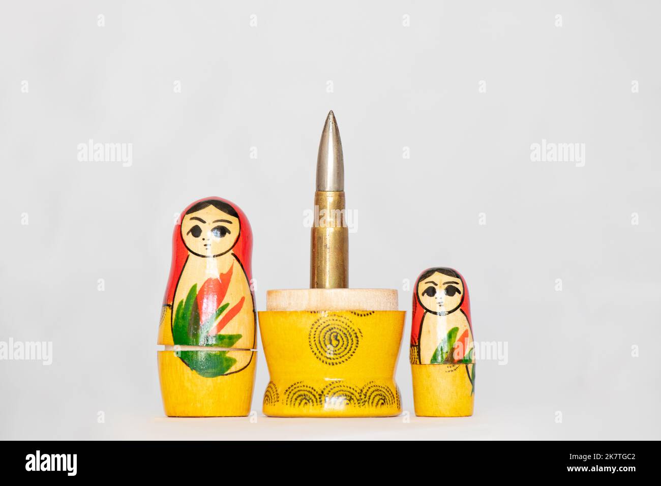 The bullet is embedded in the national Russian nesting doll on an isolated background, the country is a terrorist, war Stock Photo