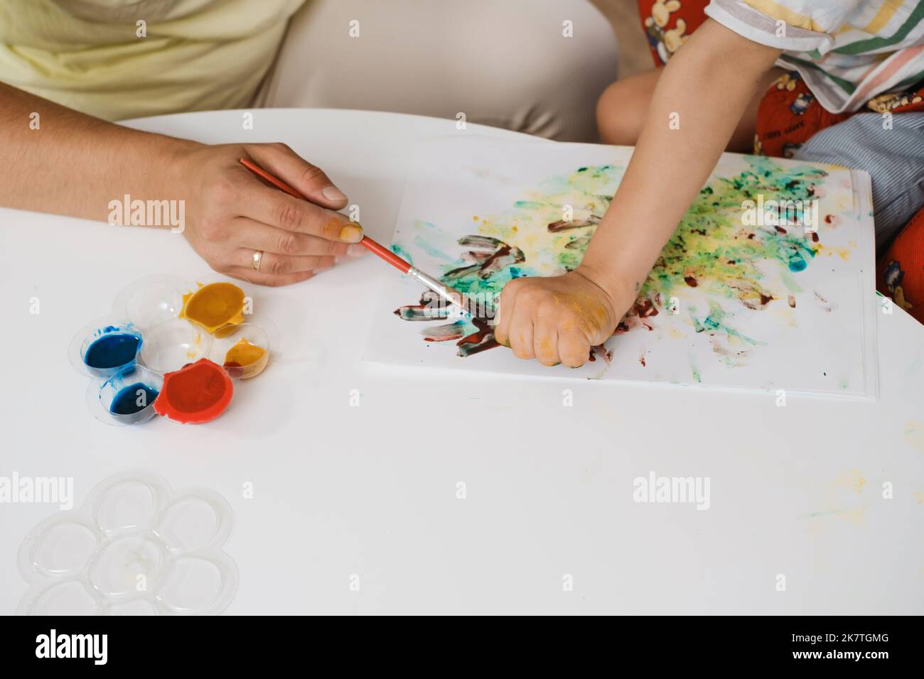 Child with cerebral palsy painting with fingers and hands boy that has
