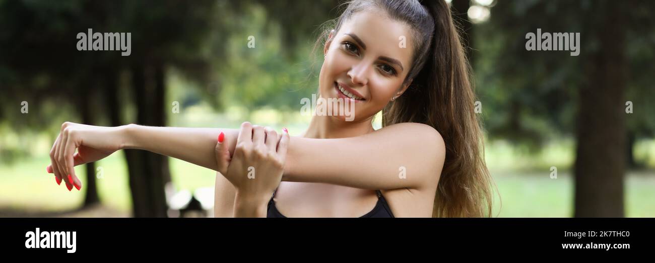 Young woman stretching arms before morning workout on fresh air Stock Photo