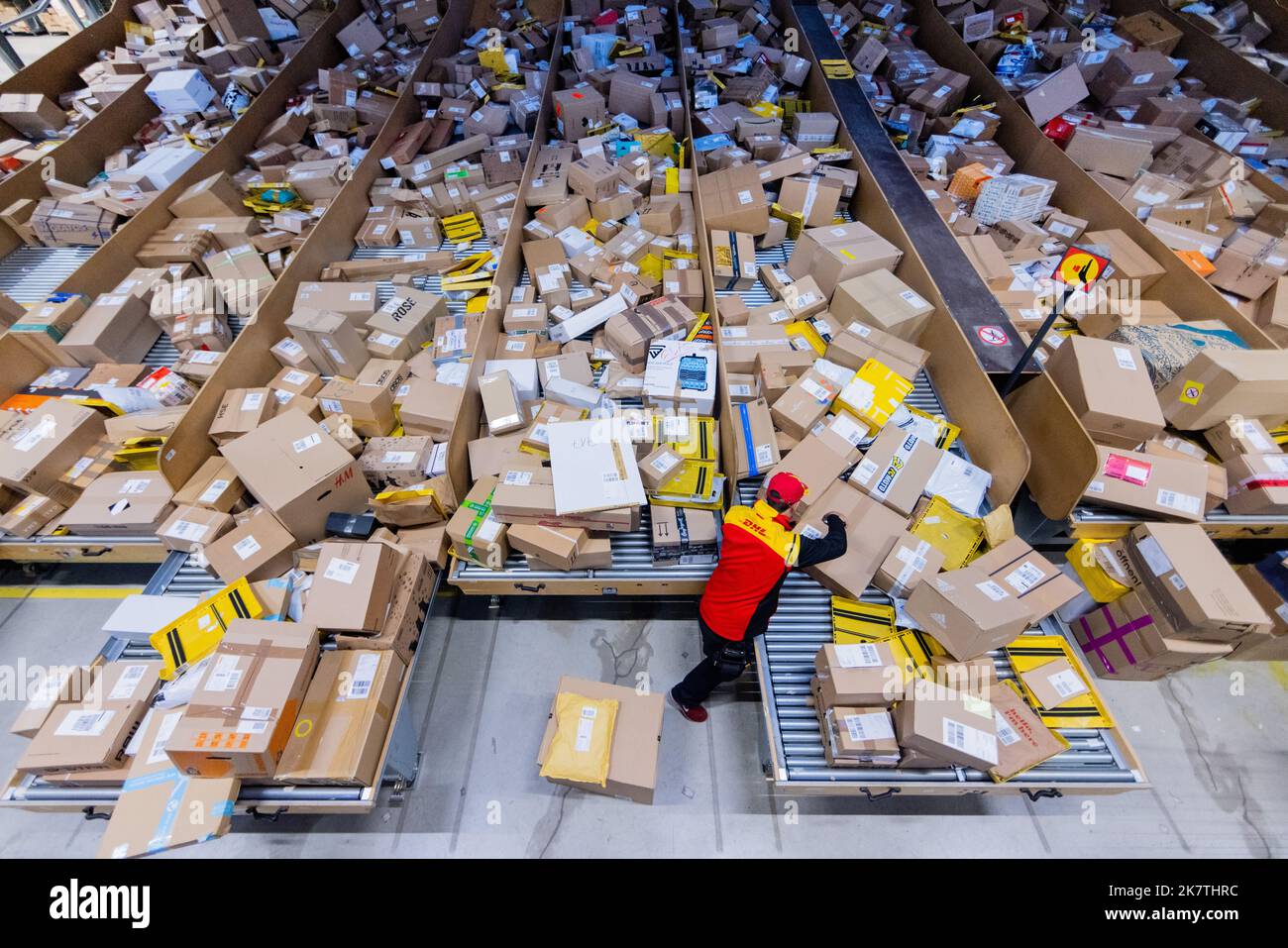 Cologne, Germany. 19th Oct, 2022. A parcel delivery driver sorts and puts  parcels into a delivery vehicle at a Deutsche Post DHL delivery base.  Deutsche Post DHL is again expecting masses of
