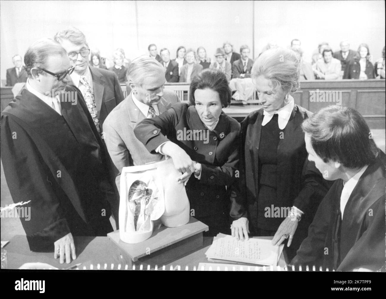 Fernsehgericht: Körperverletzung - Vor dem Gericht und einen Sachverständigen demonstriert die angeklagte Krankenschwester (Lotte Hofmann) an einem Modell, wie sie die Spritze angesetzt hat. Stock Photo