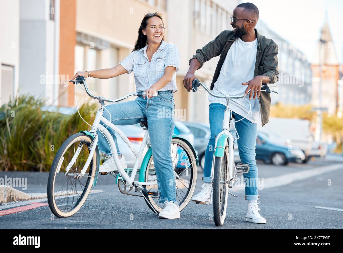 Bike, young couple and city street cycling in summer for eco friendly carbon footprint, love date and relax. Happy man, smile woman and diversity Stock Photo