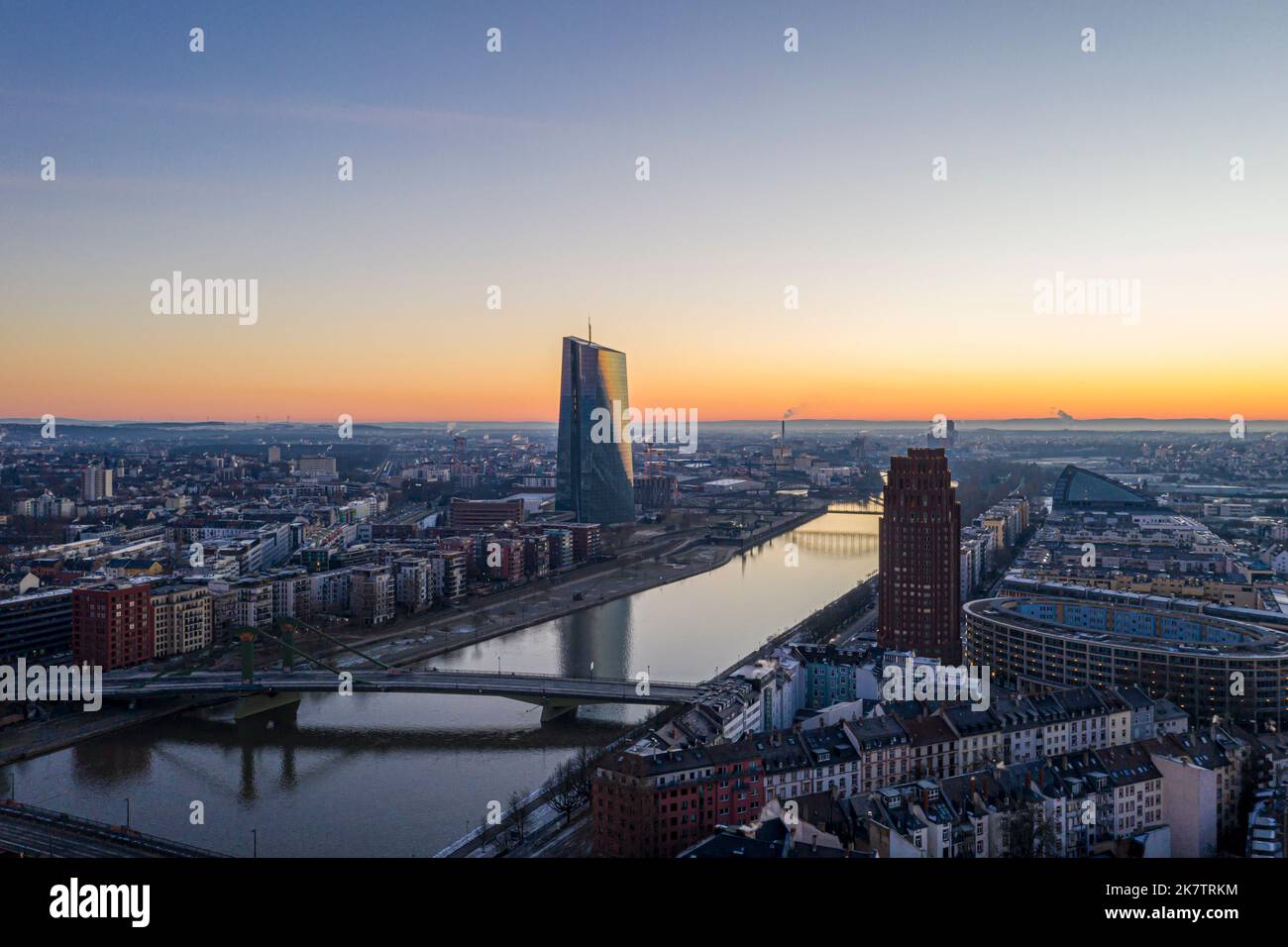 View over river Main in Frankfurt with Flößerbrücke and European Central Bank building with sun reflection in the facade during winter Stock Photo