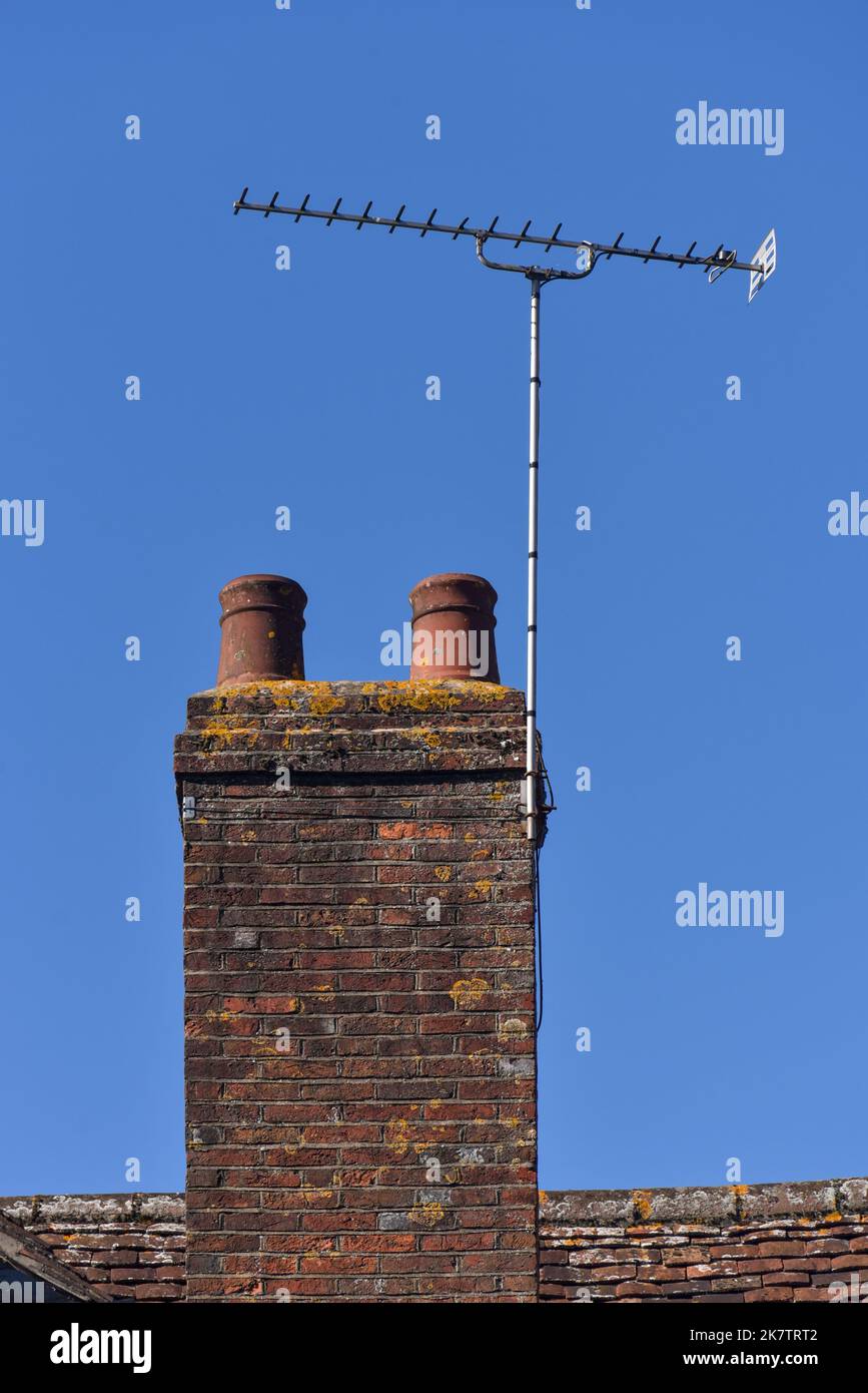 Old style brick chimney with ceramic pot on the top in a rural village in Hampshire, England. Stock Photo