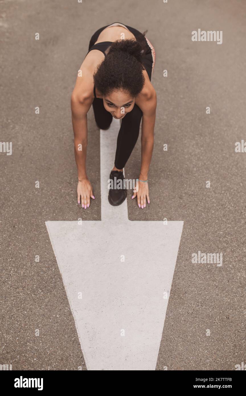 Female runner standing on the start and looking ready to to start Stock ...