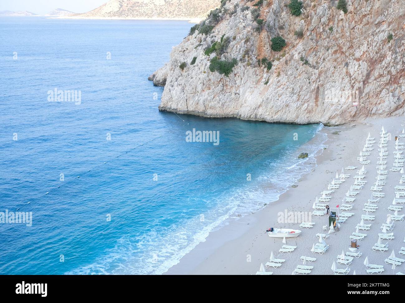 Empty Kaputas beach at Kaş Antalya. Empty beach background with sea, sand, sun bed and rocks. One of most famous beach in Turkey. No people at beach. Stock Photo