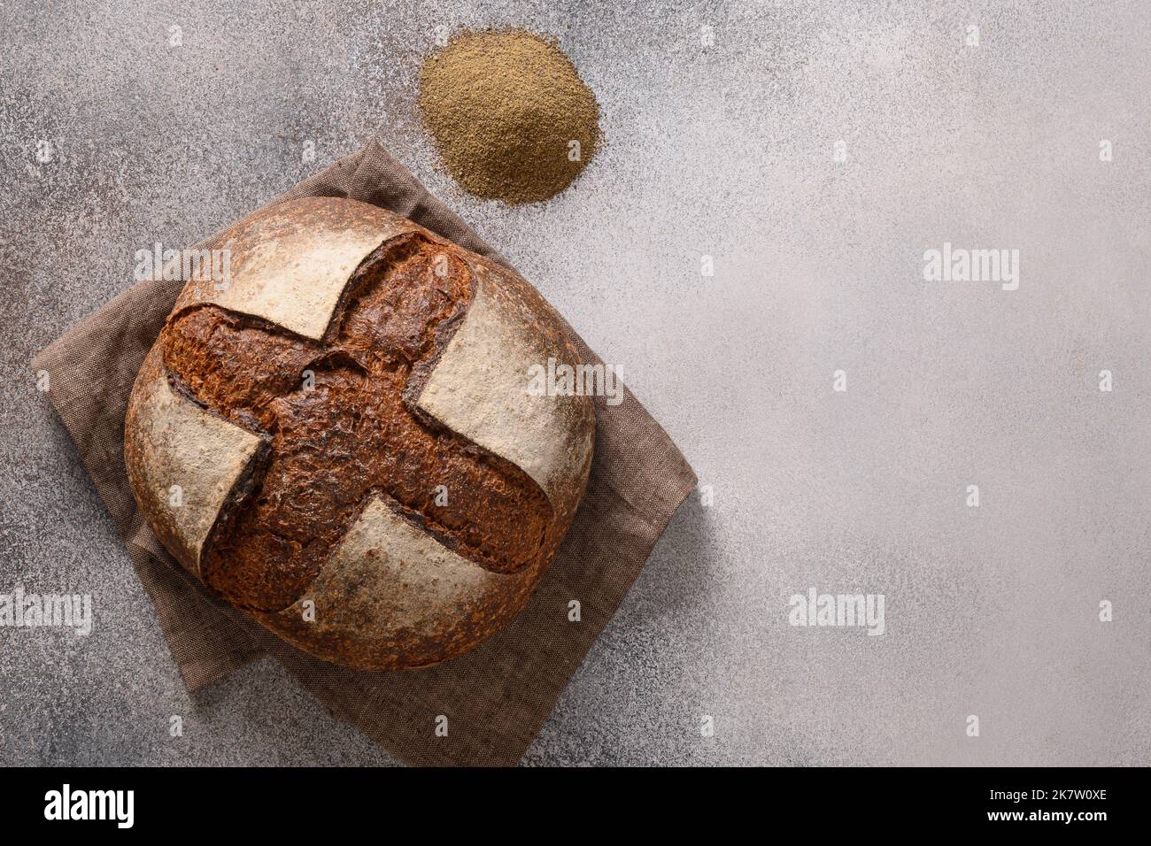 Hemp bread, seeds, hemp flour on gray background with copy space. Loaf of freshly baked