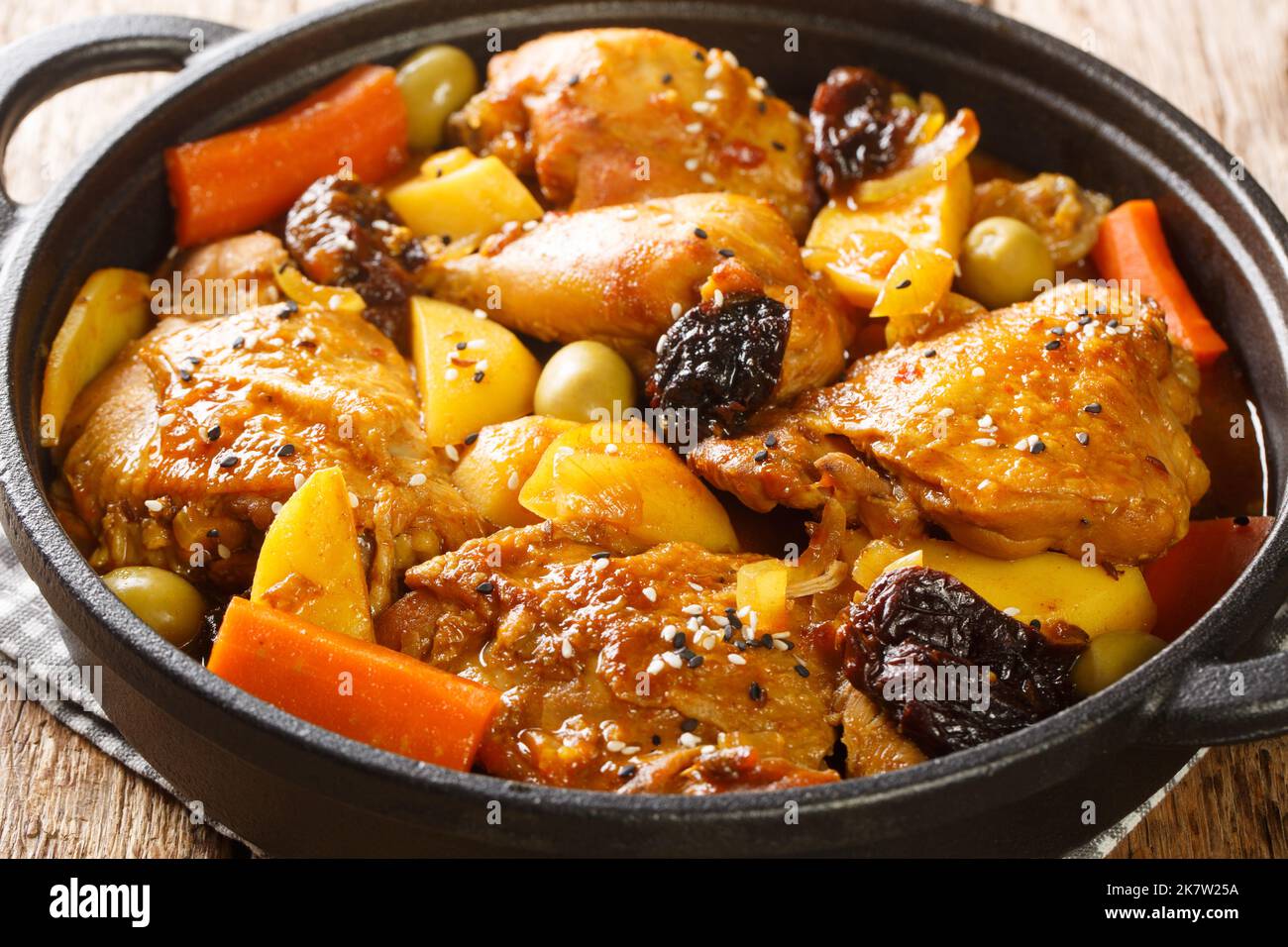 Gallo en chicha is a rooster cooked in a fermented corn drink with vegetable and spices closeup on the pan on the wooden table. Horizontal Stock Photo