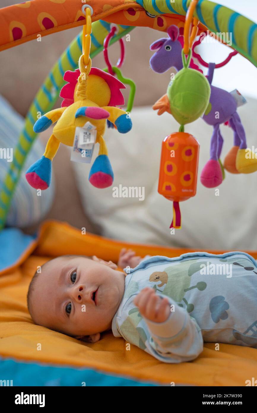 Baby playing on colorful play gym Stock Photo