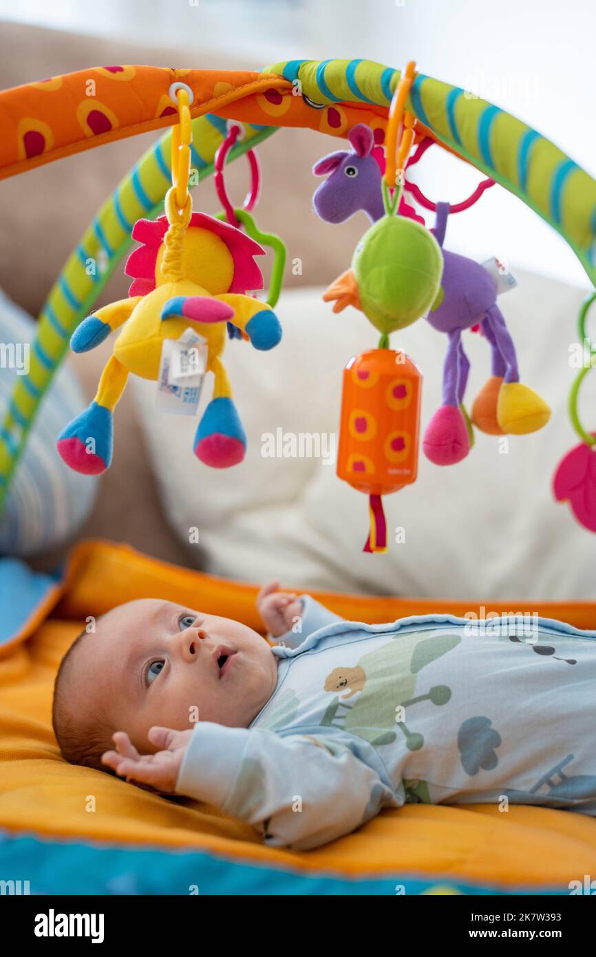 Baby playing on colorful play gym Stock Photo