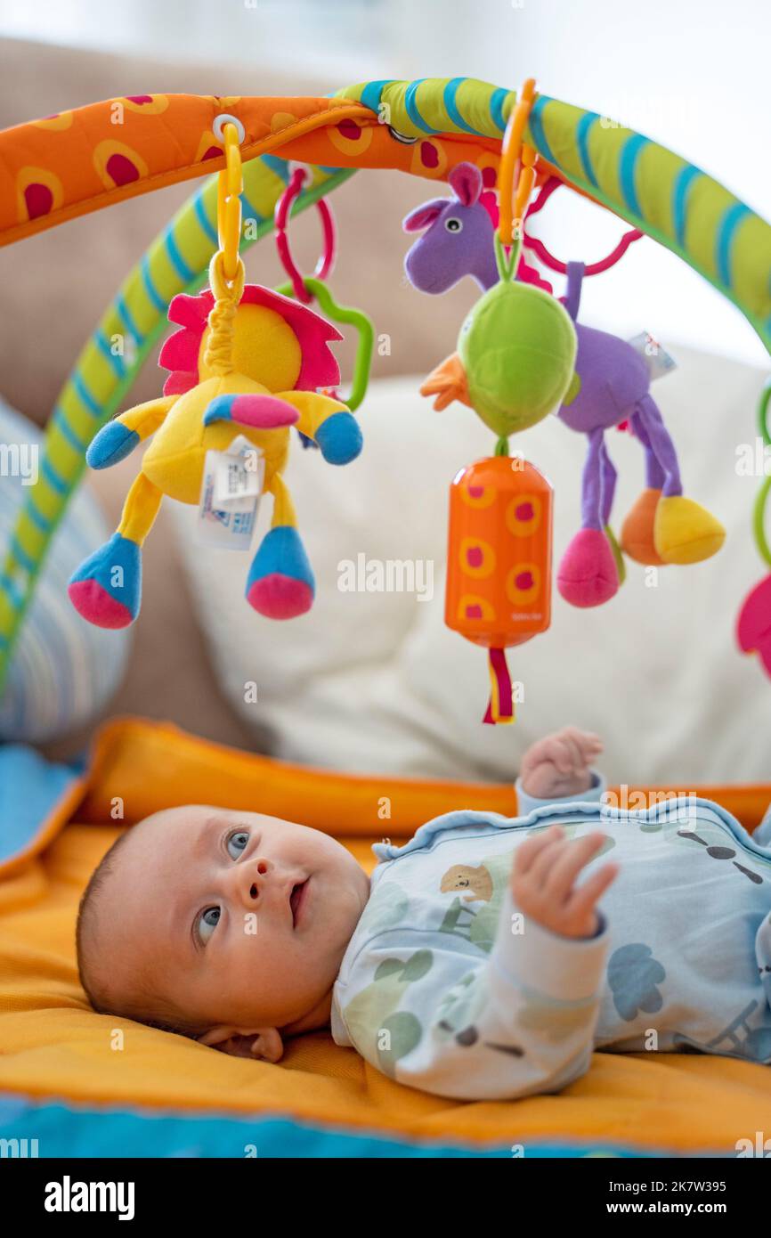 Baby playing on colorful play gym Stock Photo