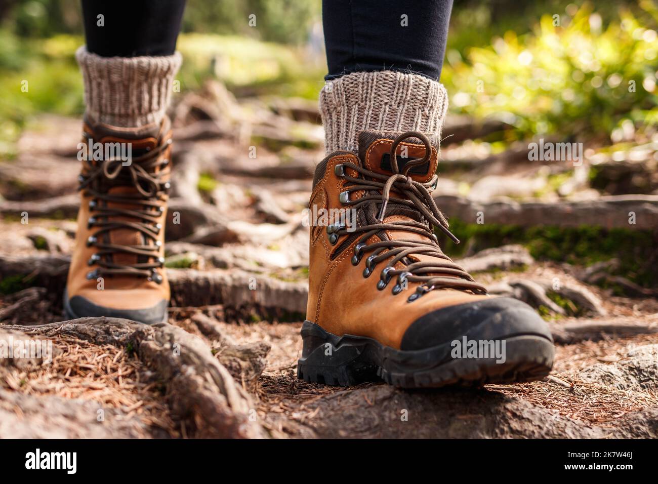Hiking boot. Legs on mountain trail during trekking in forest. Leather ankle shoes Stock Photo