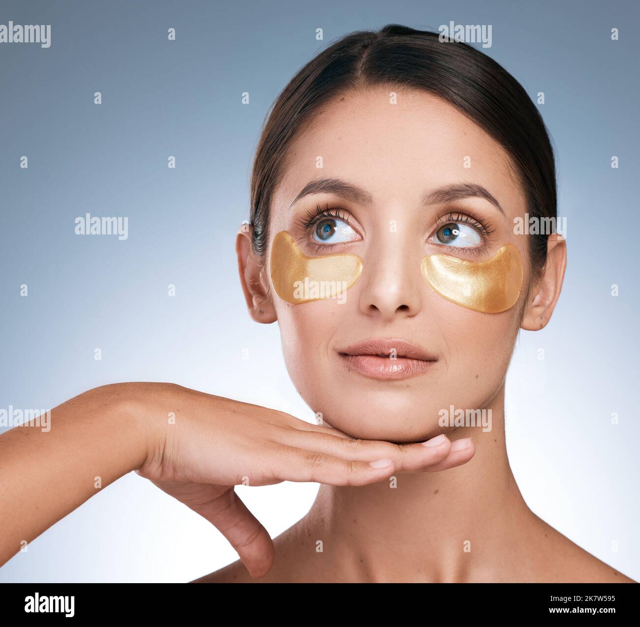 Before things come together, they have to fall apart. a young attractive woman wearing an under eye patch against a blue background. Stock Photo