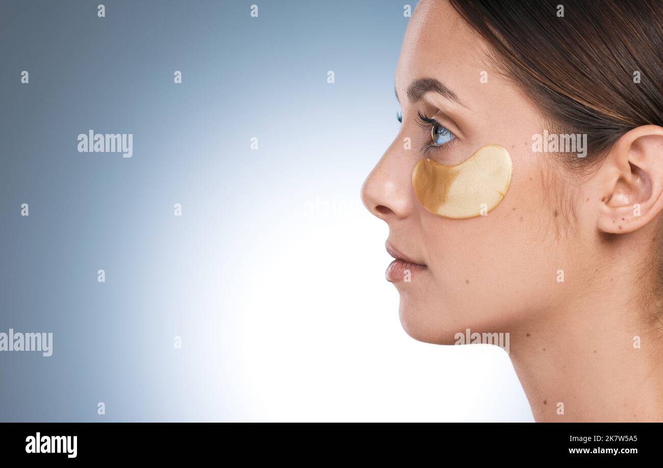 Making time for the divine. Side shot of a young attractive woman wearing an under eye patch against a blue background. Stock Photo