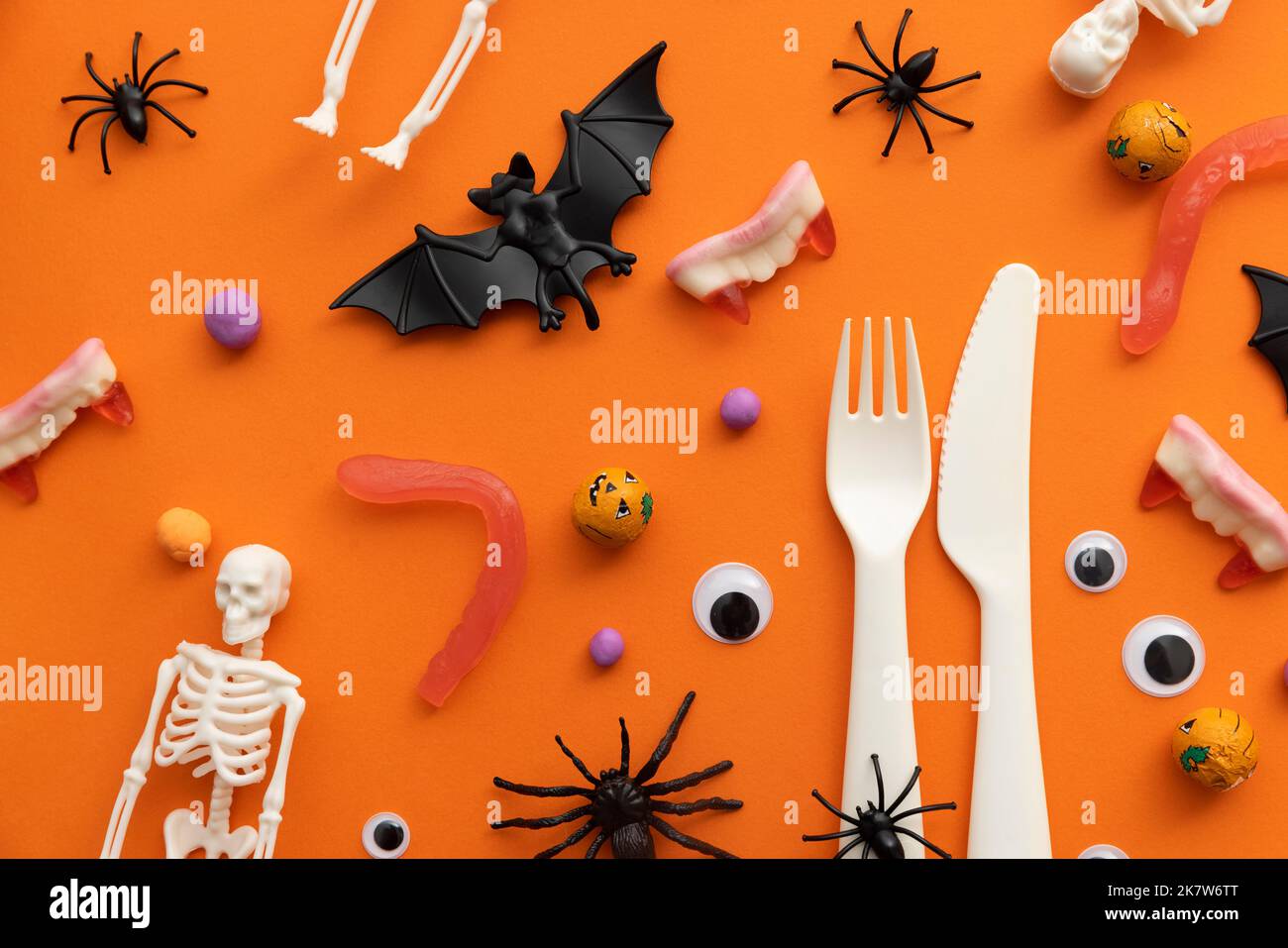 Halloween dinner party background. Cutlery with halloween decorations and sweets Stock Photo