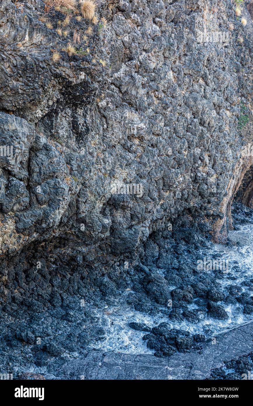Ancient pillow lava, a volcanic rock formation, visible on the shore at
