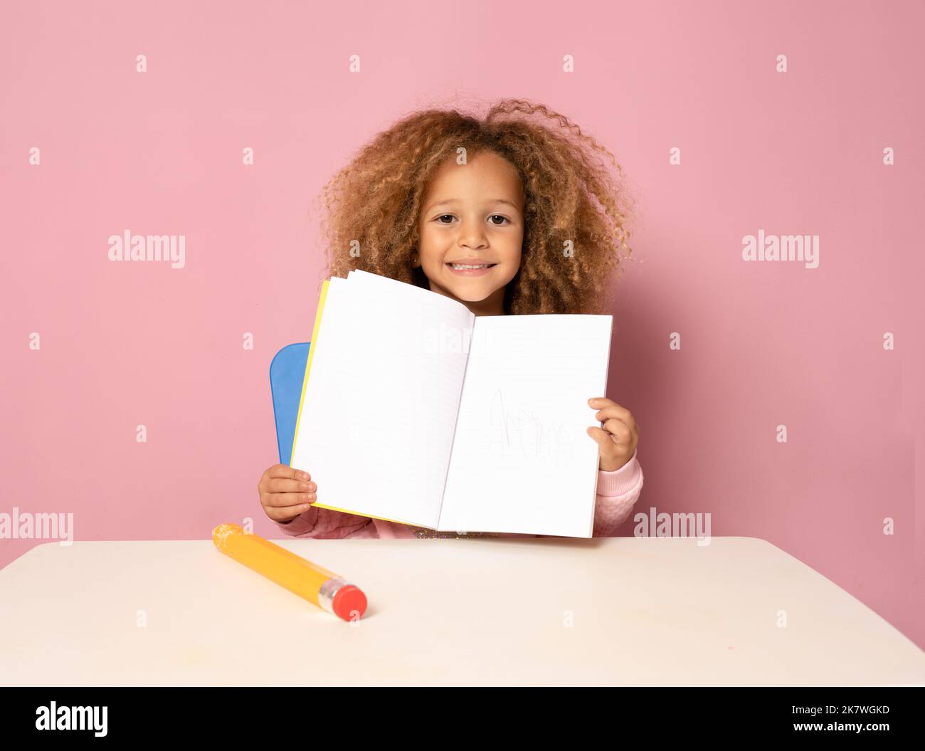 Education. Close up portrait of cute child little girl is sitting at ...