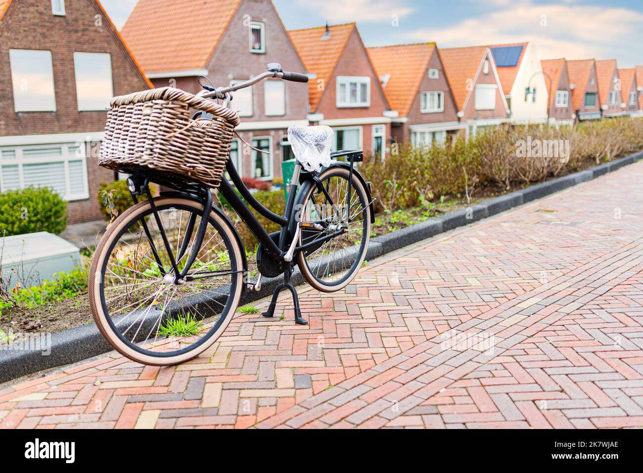 bicycle with handlebar pannier parked at curb in dutch village Stock Photo