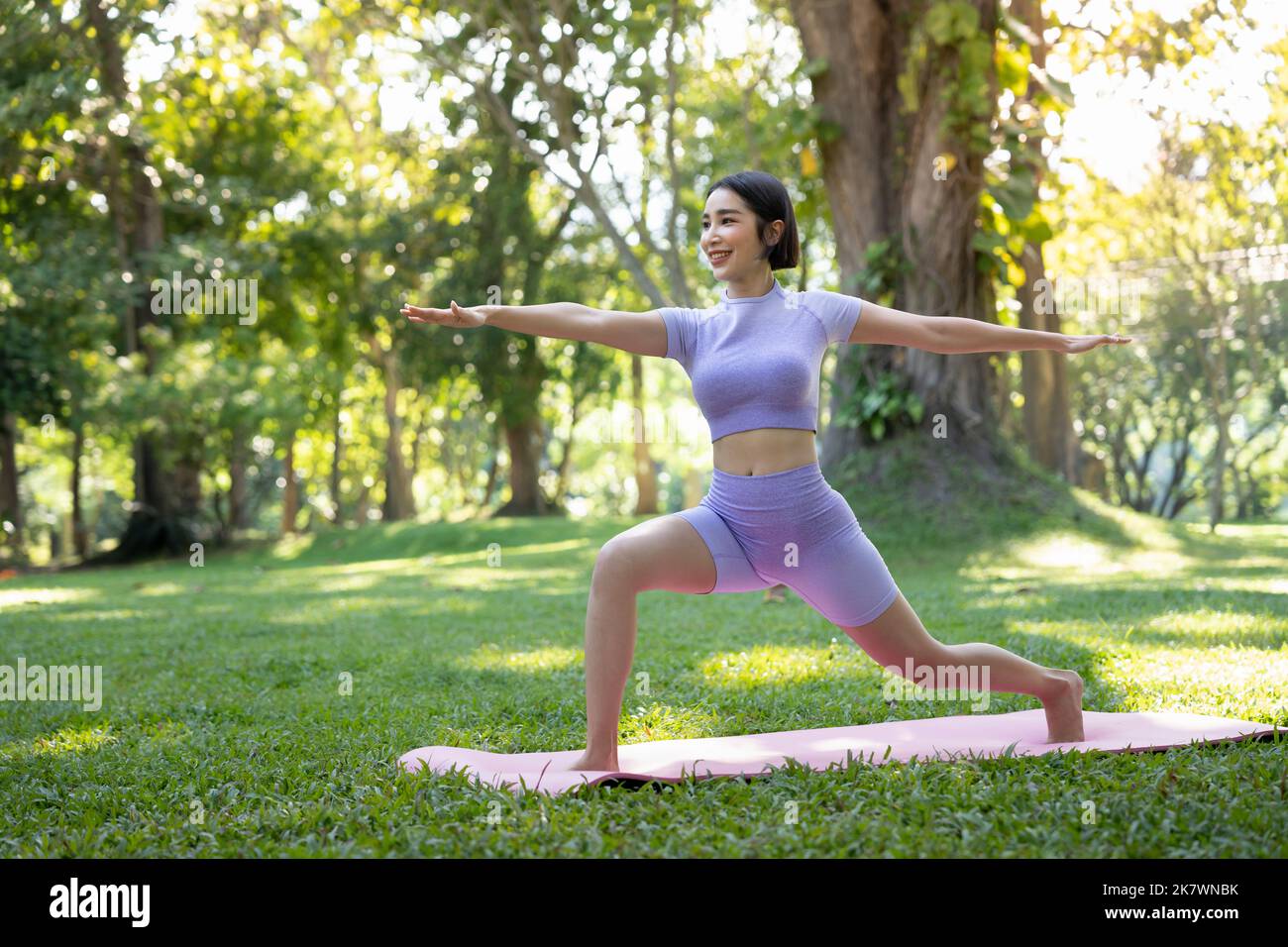 Portrait of a young woman doing yoga in the garden for a workout. Concept of lifestyle fitness and healthy. Asian women are practicing yoga in the Stock Photo