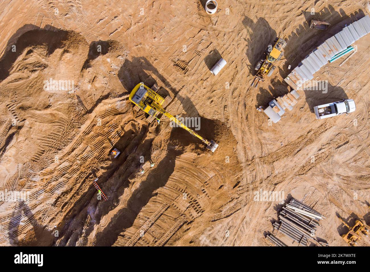 Construction site excavator digs trench to lay sewer line and connect