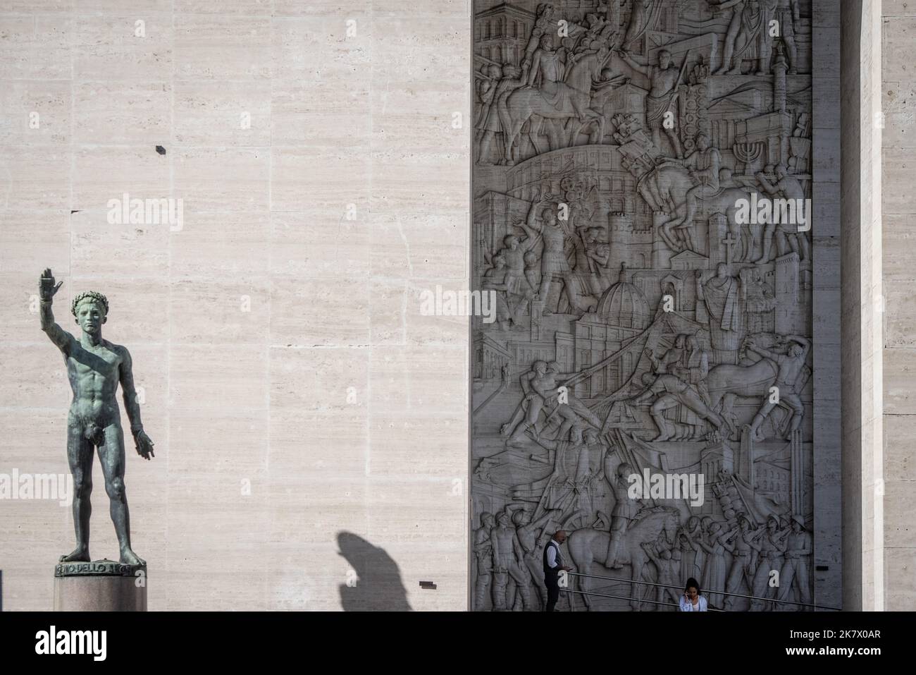 Rom, Italy. 19th Oct, 2022. People stand in front of the entrance of Palazzo degli Uffici in front of a relief by artist Publio Morbiducci that shows, among others, former Italian dictator Mussolini sitting on a horse. (to dpa 'Ahead of 100th anniversary of the seizure of power by the fascists in Italy') Credit: Oliver Weiken/dpa/Alamy Live News Stock Photo