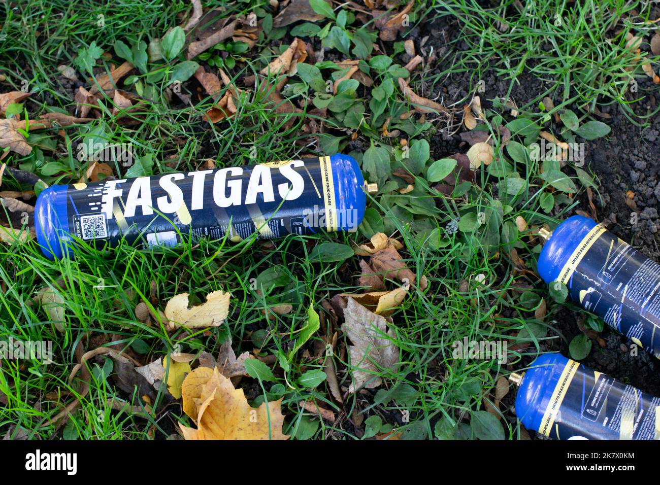 Discarded Fastgas Nitrous Oxide gas canister containers on grass. Stock Photo