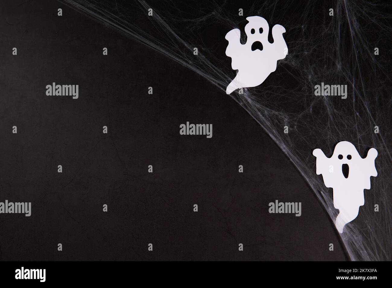 Spider web with white ghosts on black background Stock Photo