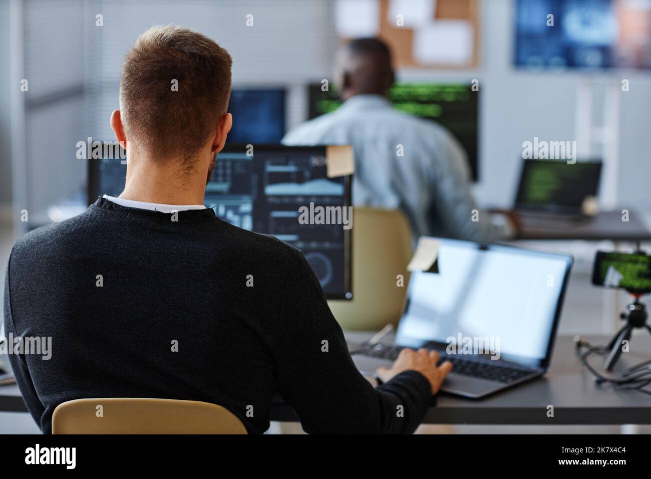 Back view of male programmer or data specialist using computer in ...