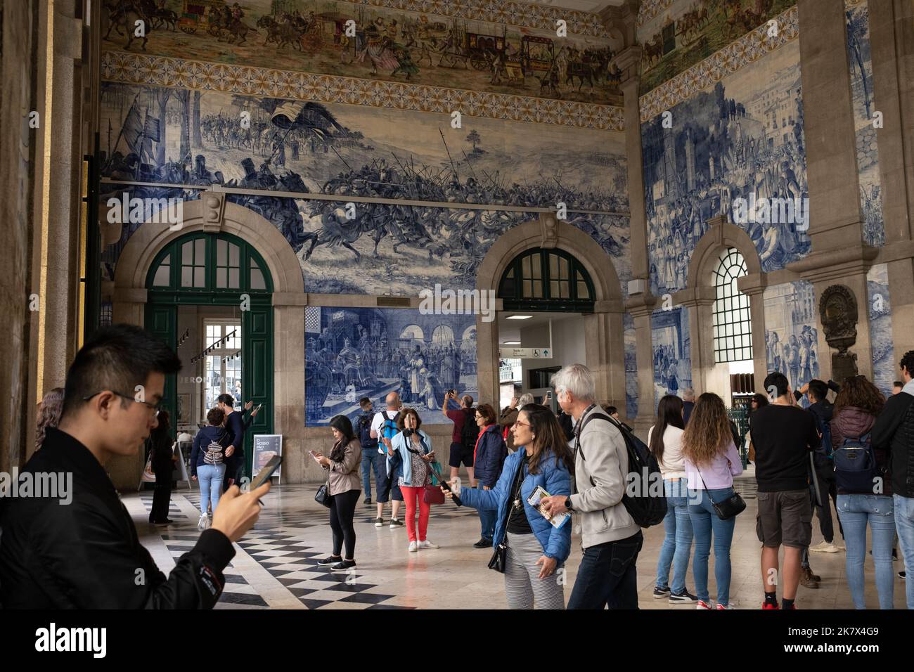 Tourists in Sao Bento train station photographing the blue tile murals, in Porto, Portugal, 16 October, 2022. Stock Photo
