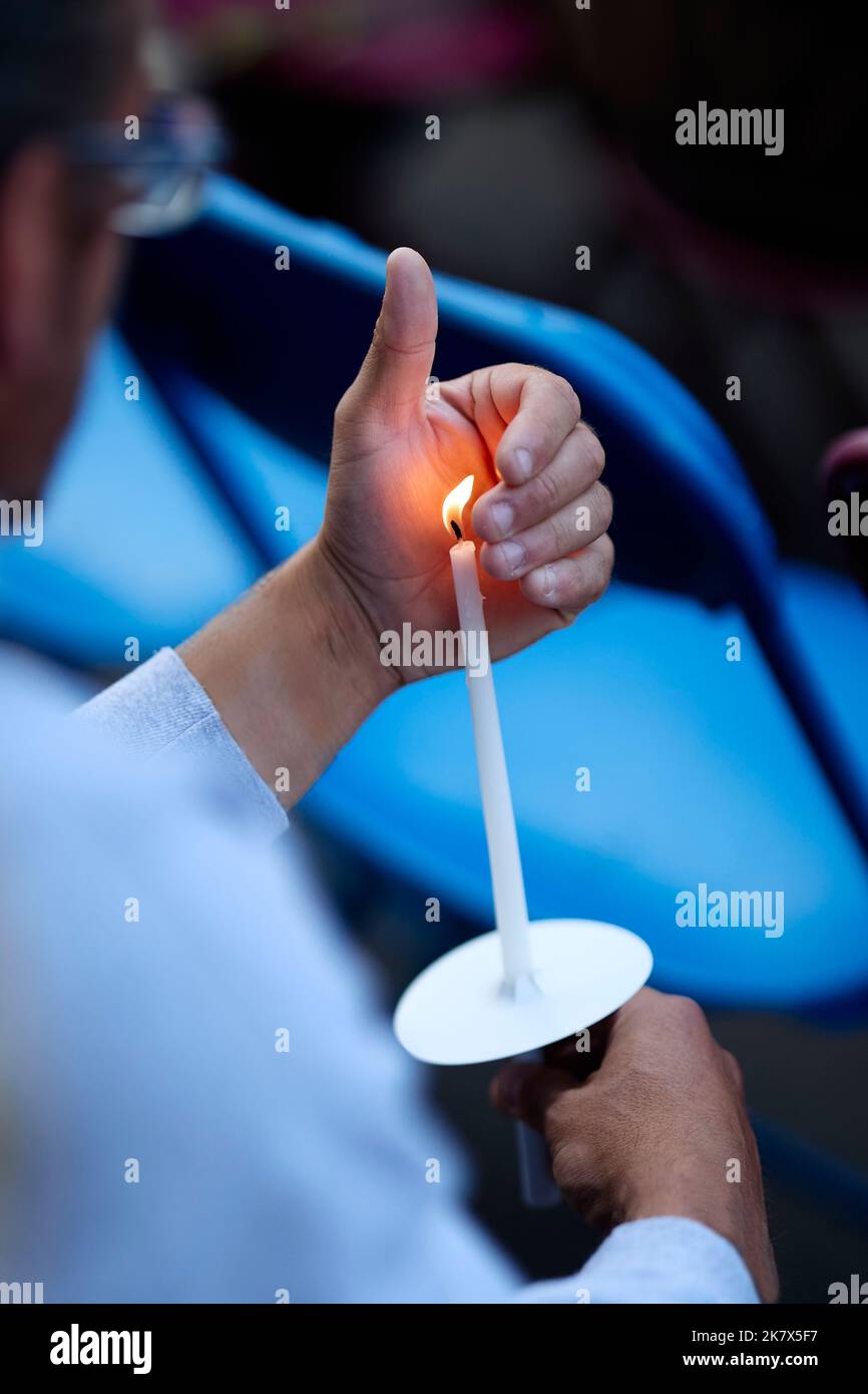Man holding lit candle outdoors Stock Photo