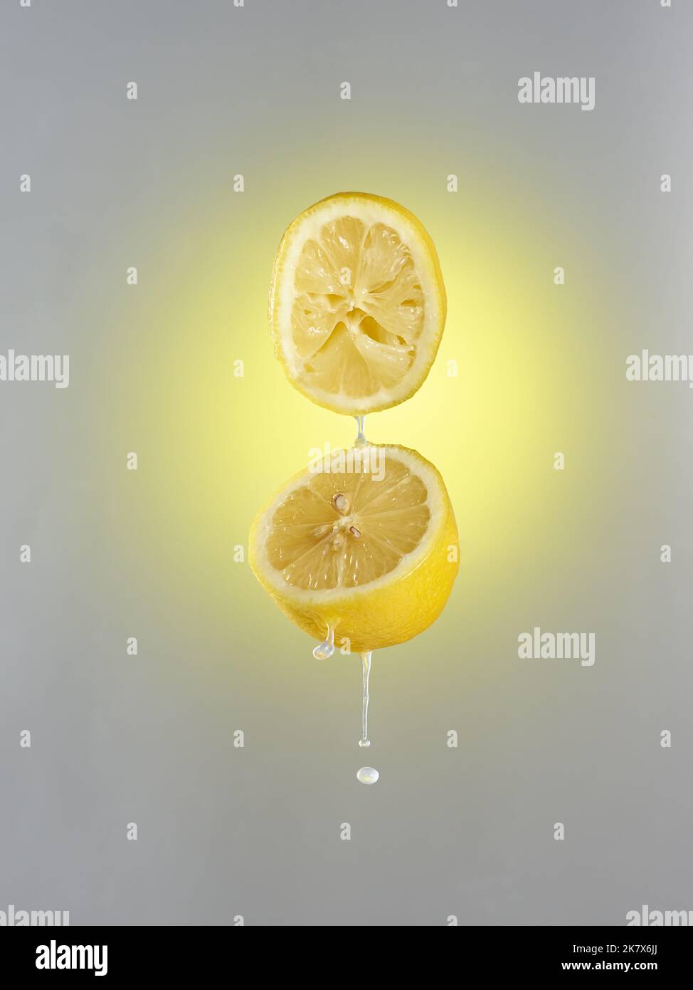 Lemon cut into two parts with a splash of juice Stock Photo