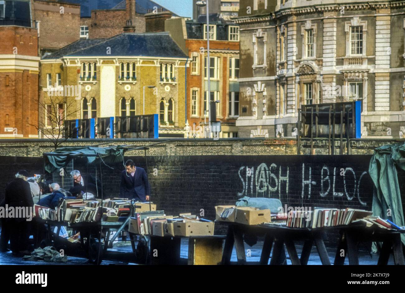 1983 archive image of secondhand book stall and Smash H-Blocks graffiti in Farringdon Road, London. Stock Photo