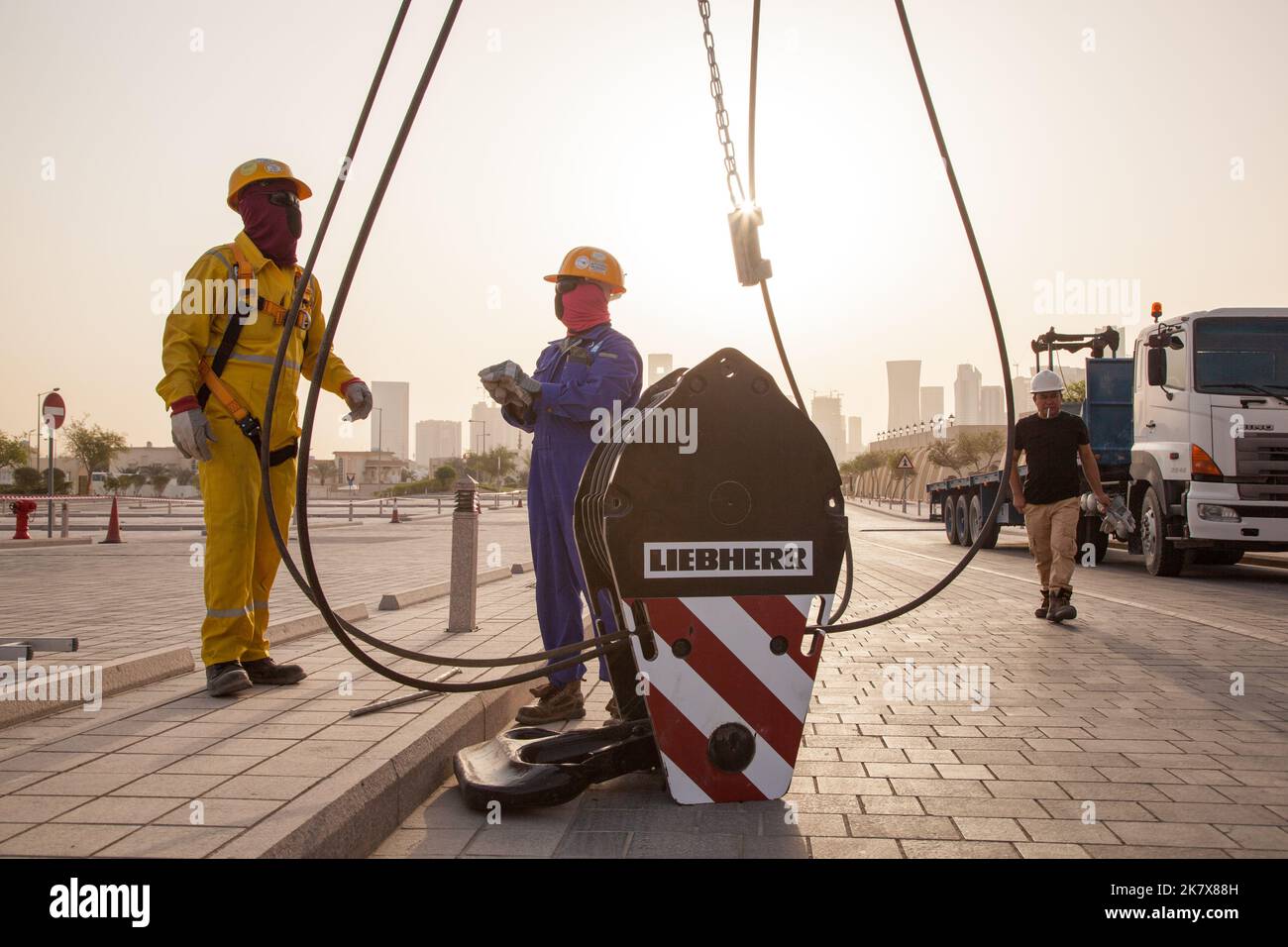 Doha, Qatar, December 18,2019 : Construction workers preparing a crane for work in the background skyscrapers in Doha. Stock Photo