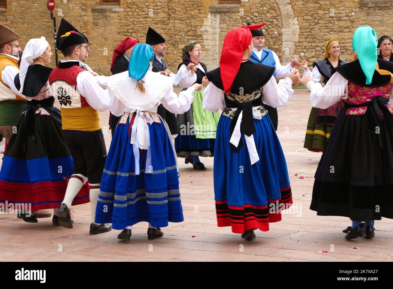 A folk dance group in traditional costumes dancing to bagpipe music in