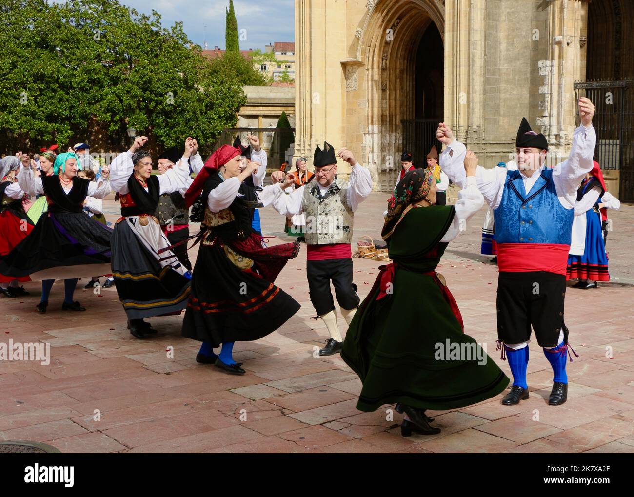 A folk dance group in traditional costumes dancing to bagpipe music in