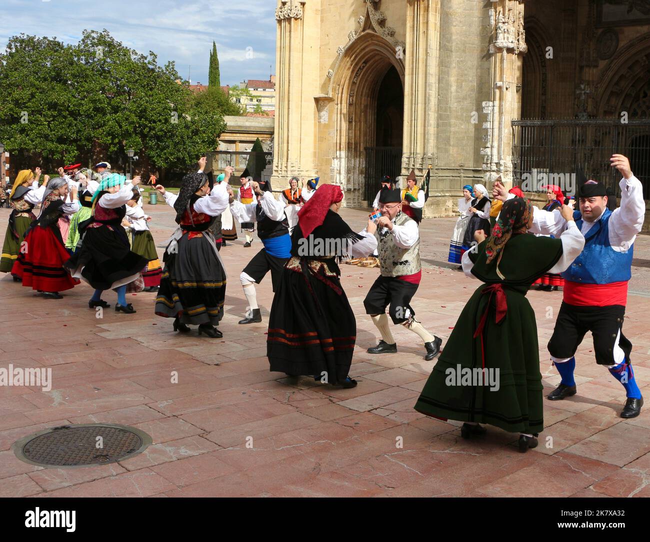 A folk dance group in traditional costumes dancing to bagpipe music in front of Oviedo cathedral during the Disarmament Parties 15 October 2022 Spain Stock Photo