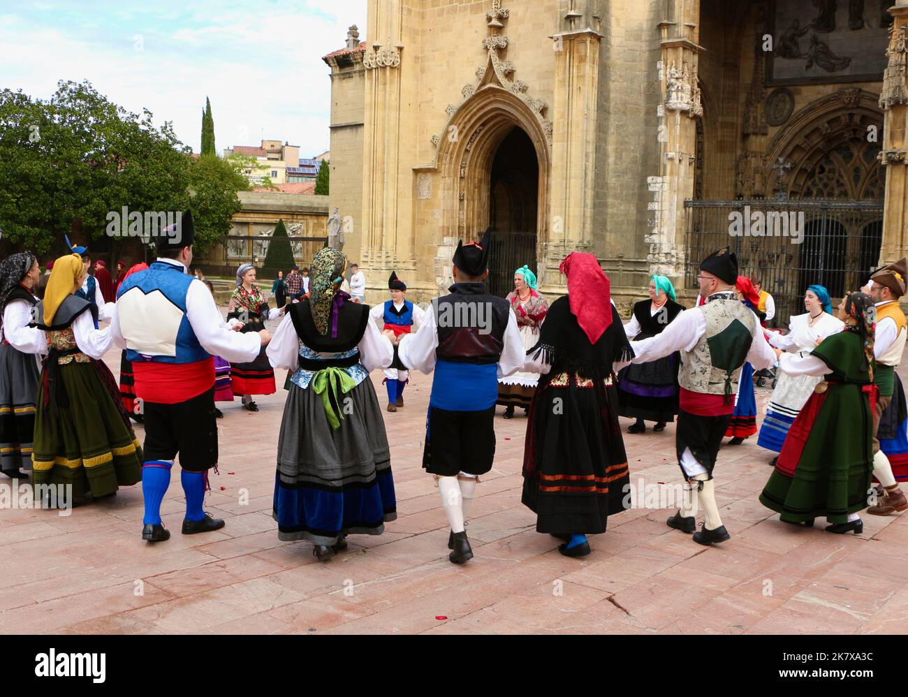A folk dance group in traditional costumes dancing to bagpipe music in