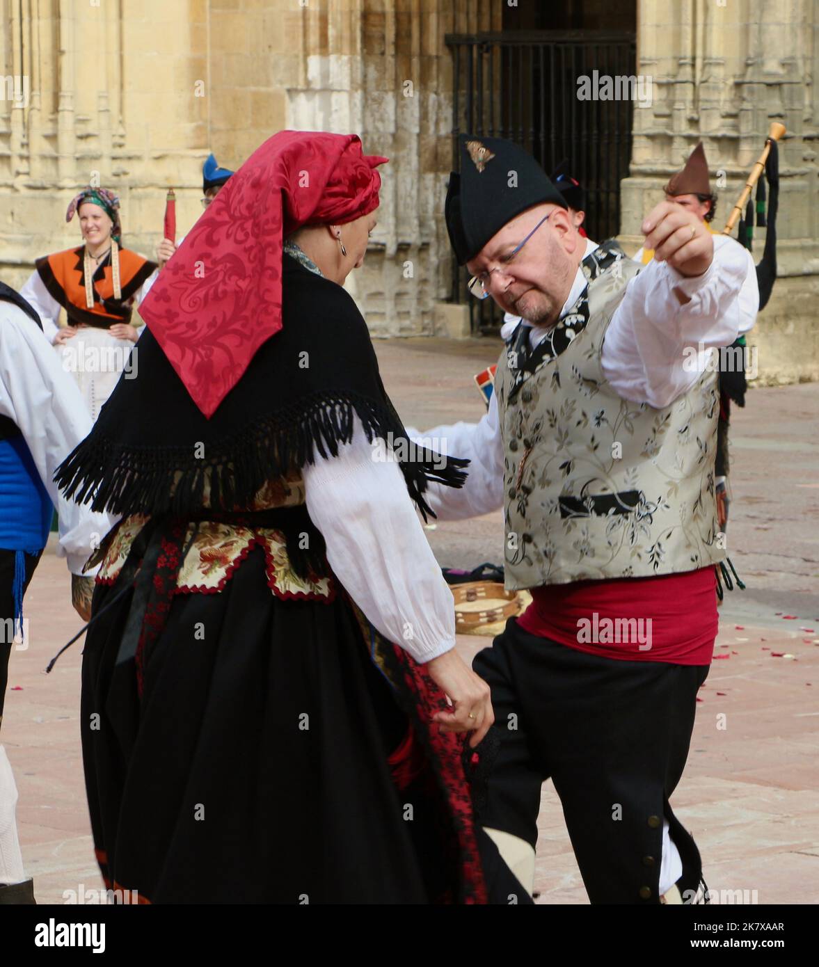 A folk dance group in traditional costumes dancing to bagpipe music in