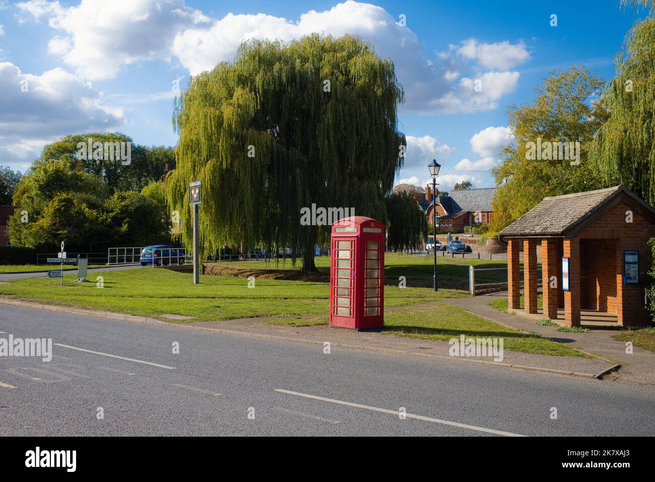 The village green at Grundisburgh, Suffolk with the old school in the background and a red phone box Stock Photo