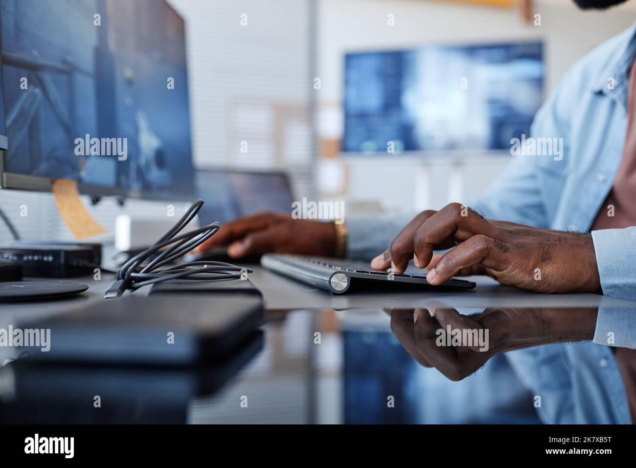 Close up of black man playing shooter video game with focus on hands at keyboard, copy space Stock Photo